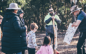 Man presenting a diagram board tyo a group of parents, children and a Reservoir Range.