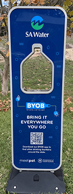 A blue, portable drinking fountain, from behind.